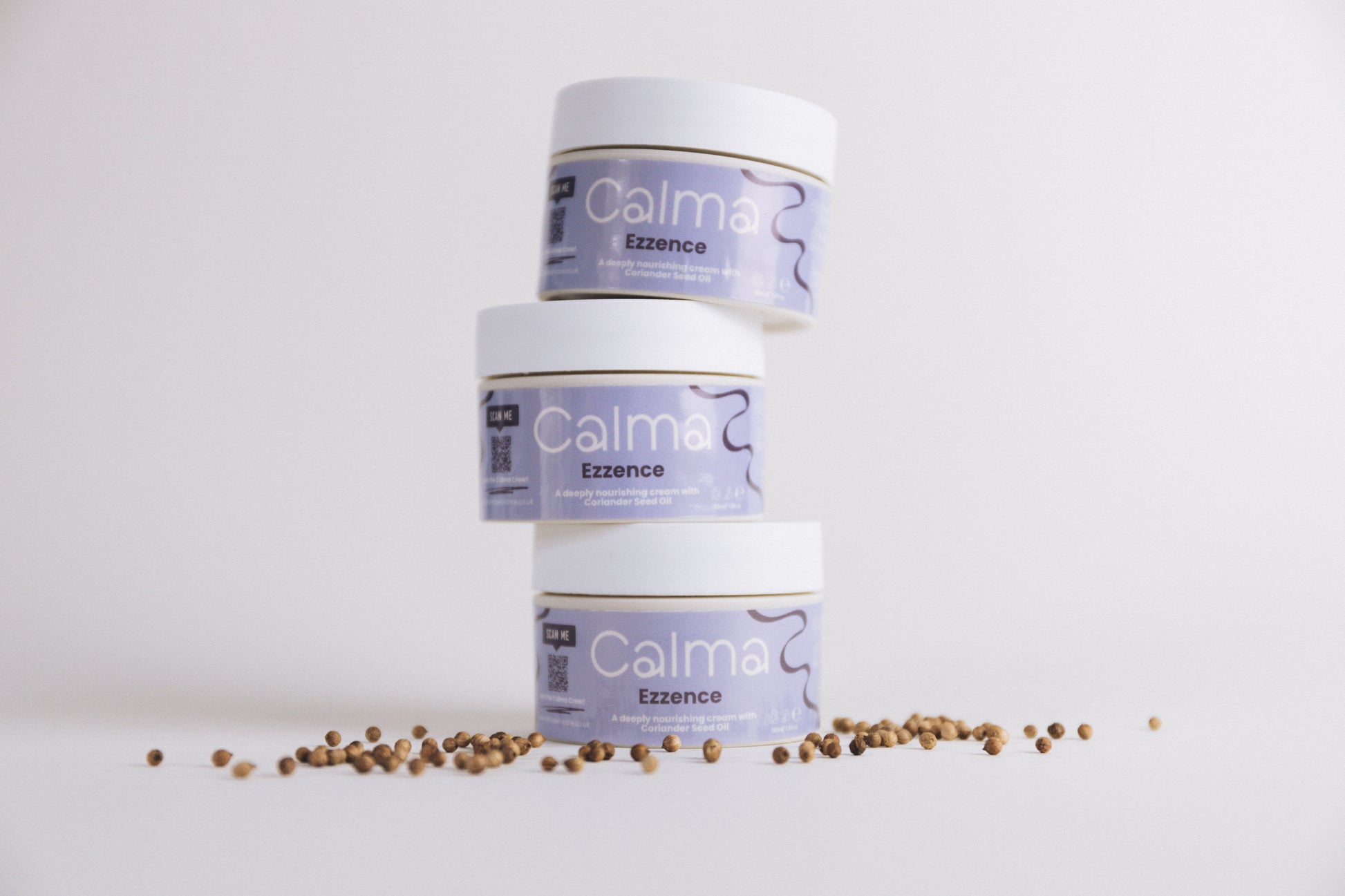Three Calma Ezzence containers with a small amount of seeds on a white background